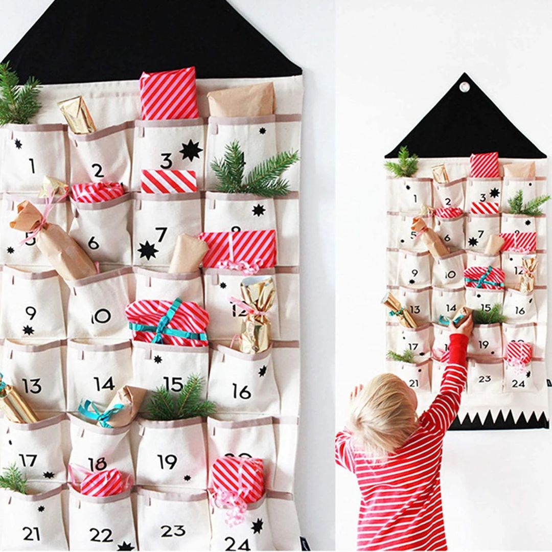 Fabric advent calendar hung on a wall with a child reaching for a pocket