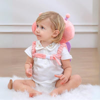 Baby sitting upright wearing the pink butterfly head protector