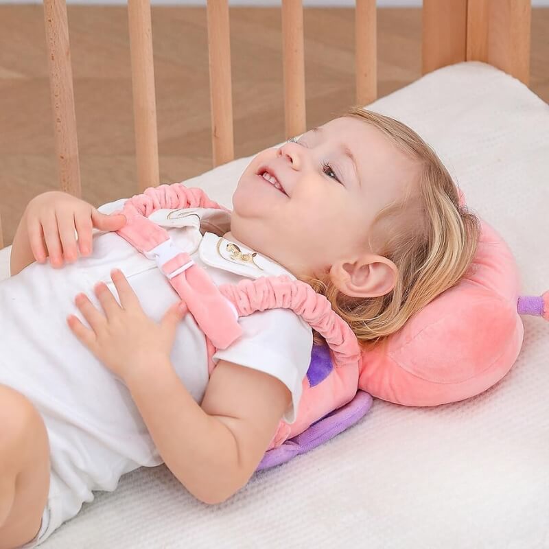 Baby lying on their back in a cot wearing the head protector