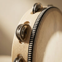 Close-up of the tambourine's metal jingles and wooden rim