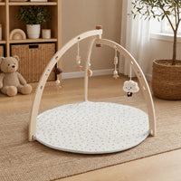 Baby Play Gym Wooden Arch & Mat set out on a real table at home