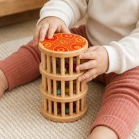 Close-up of a child's hands using the Baby Rain Stick Wooden Sensory Toy