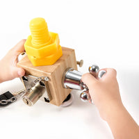 Toddler twisting the large yellow screw on the busy cube