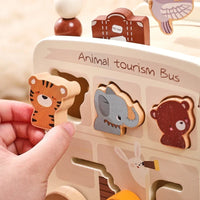 Child fitting animal shapes into the wooden tourism bus board
