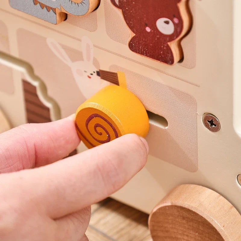 Hand sliding a wooden roller through the animal bus panel