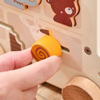 Hand sliding a wooden roller through the animal bus panel