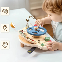 Toddler playing at the wooden activity dashboard on legs