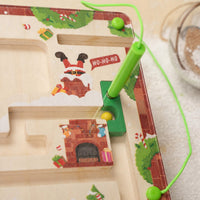Close-up of the magnetic pen guiding a bead through the Christmas maze