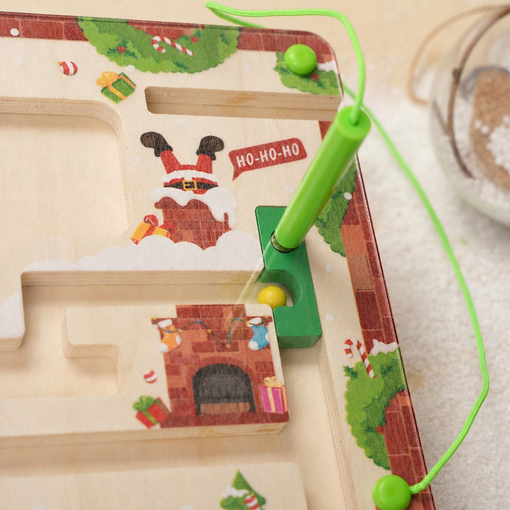 Close-up of the magnetic pen guiding a bead through the Christmas maze