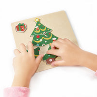 Small hands completing the decorated Christmas tree puzzle