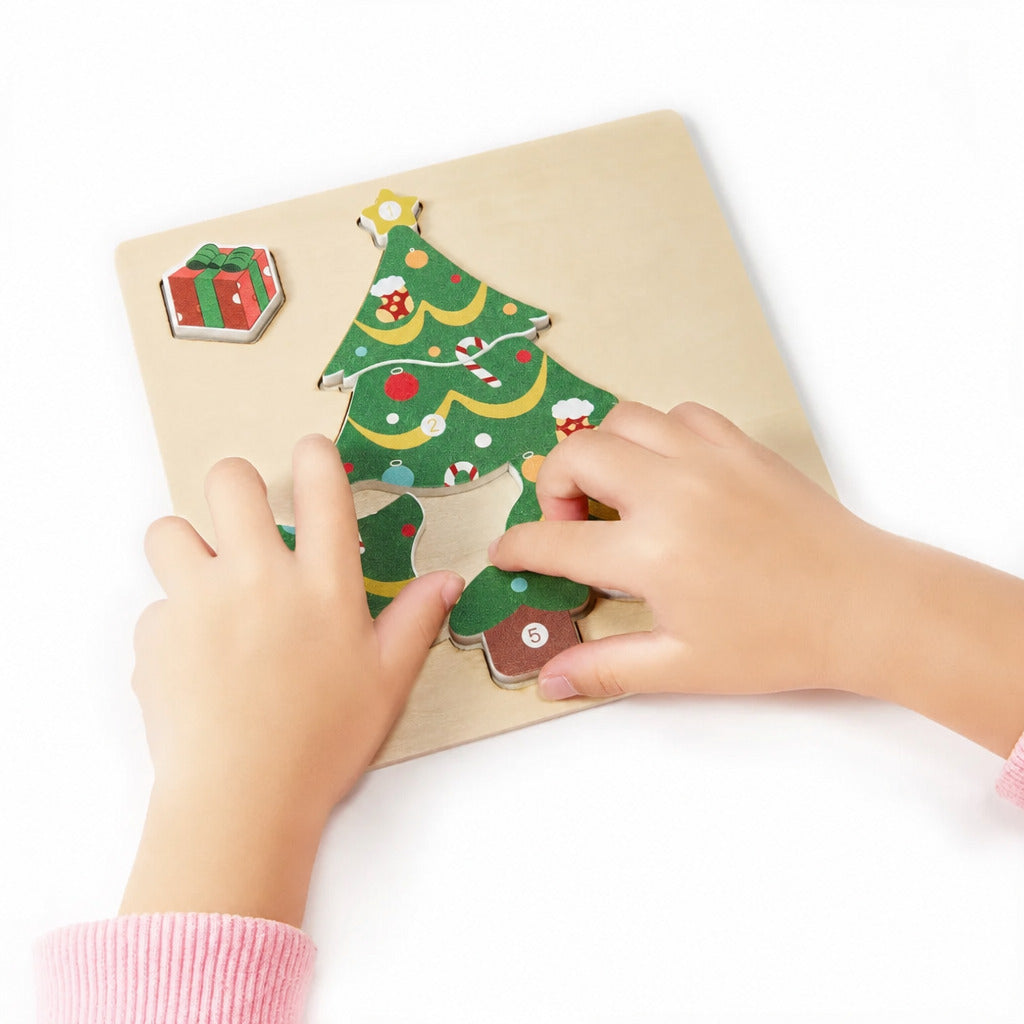 Small hands completing the decorated Christmas tree puzzle