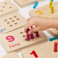 Close-up of a child fitting pegs into the number nine tile