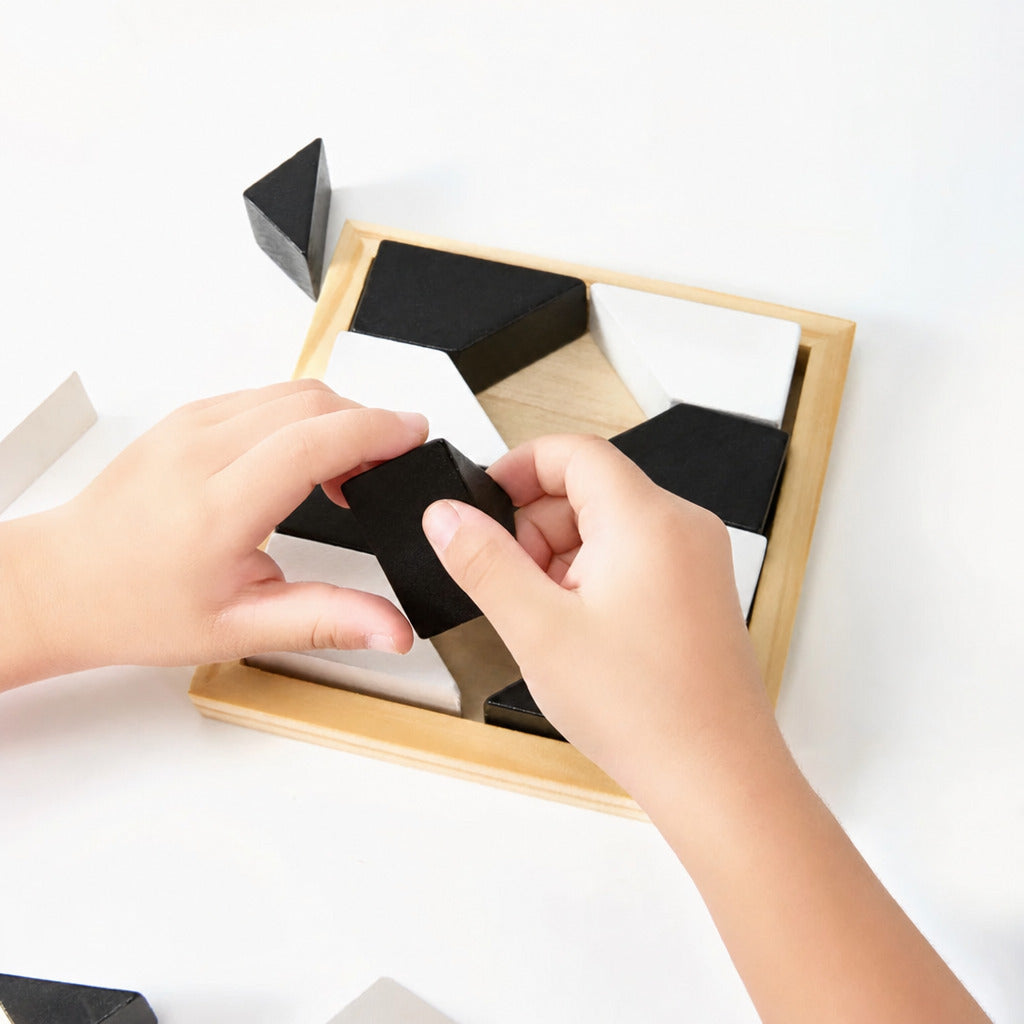 Child arranging black geometric pieces on the wooden puzzle frame