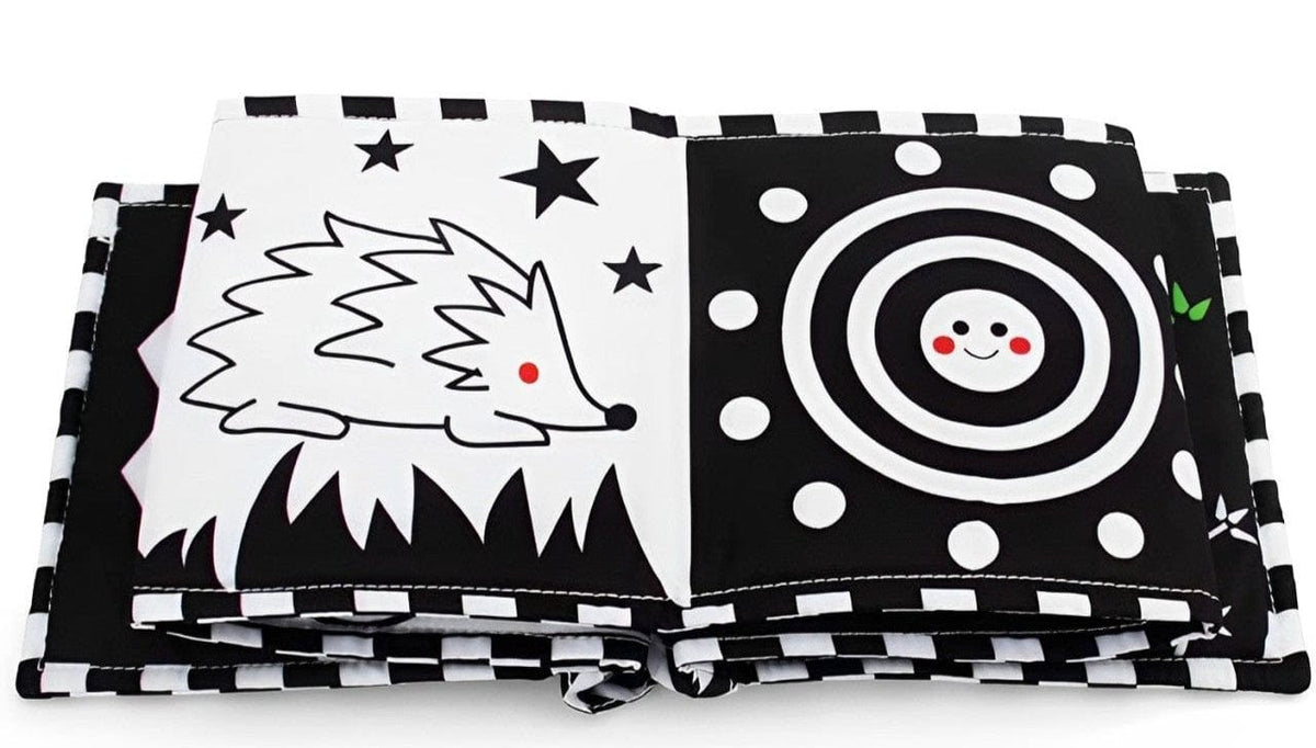 Black and white fabric book opened on hedgehog and spiral pages