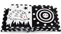 Black and white fabric book opened on hedgehog and spiral pages