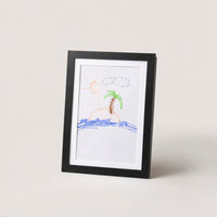 Black kids art frame standing upright with a crayon drawing