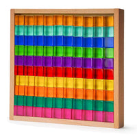 Rainbow acrylic light-catching blocks arranged in a wooden tray