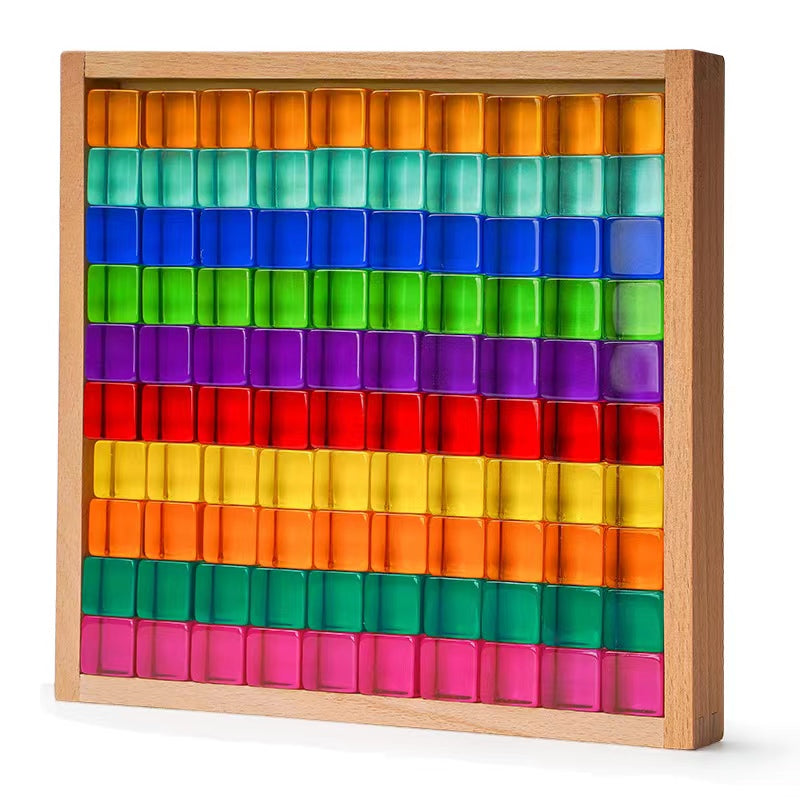 Rainbow acrylic light-catching blocks arranged in a wooden tray