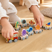 Close-up of a child's hands using the Magnetic Wooden Train Ocean Animals 11-Piece Set