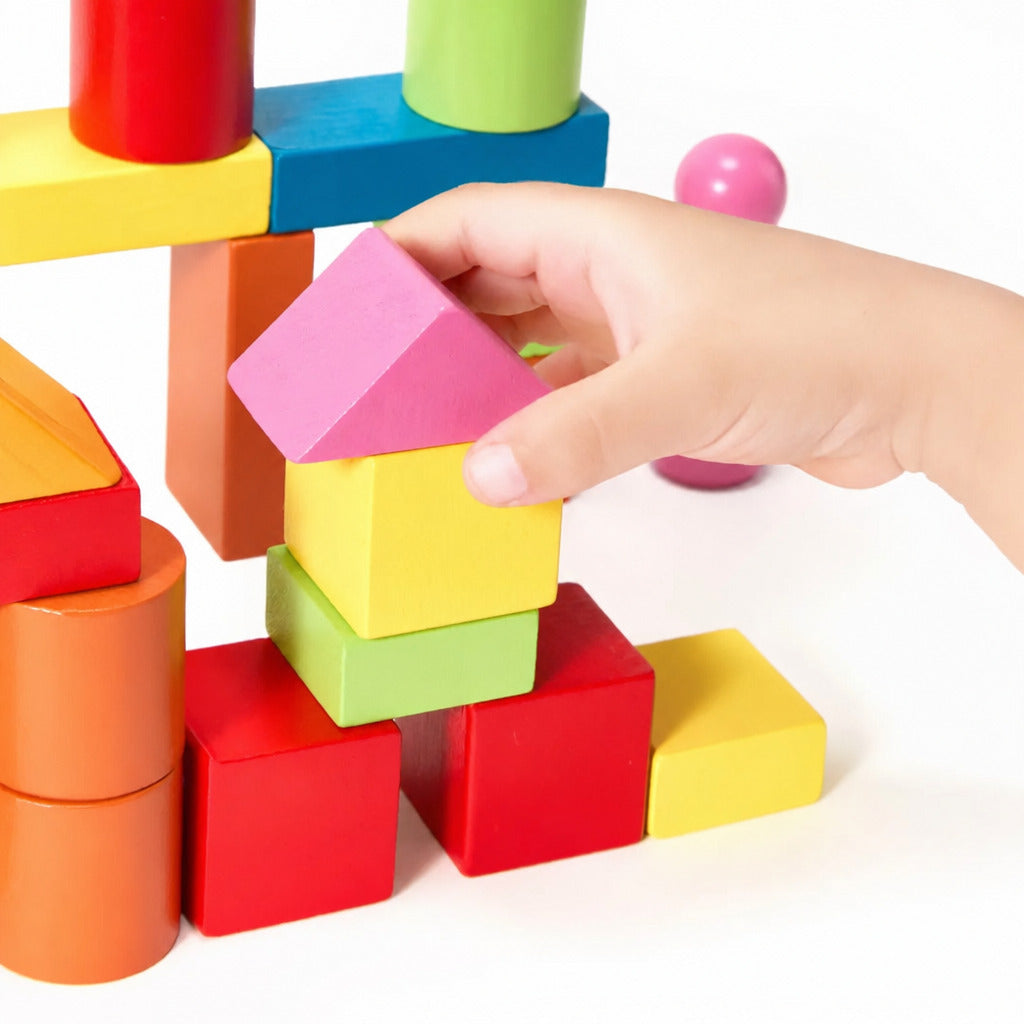 Small hand placing a green block on top of a colourful tower