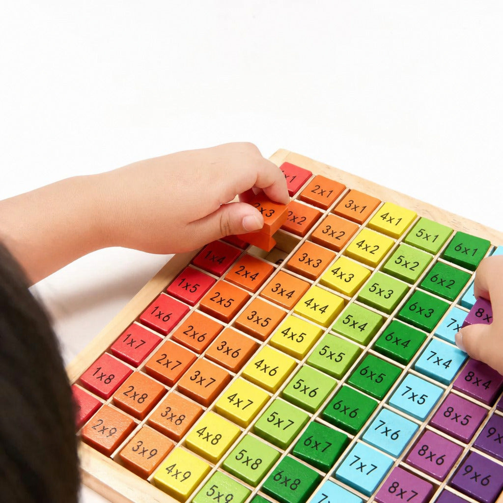 Child placing tiles onto the wooden multiplication table board