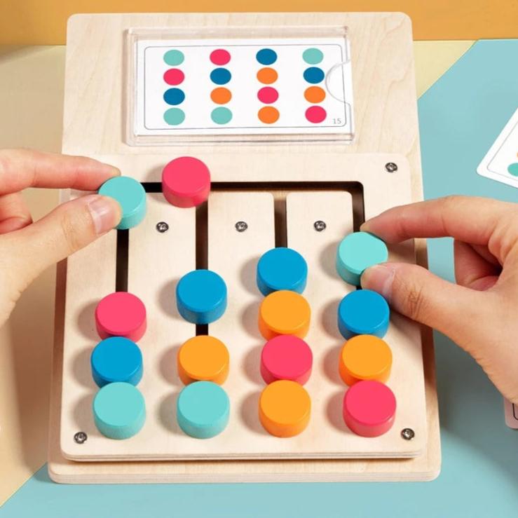 Hands sliding coloured discs along the pattern matching board