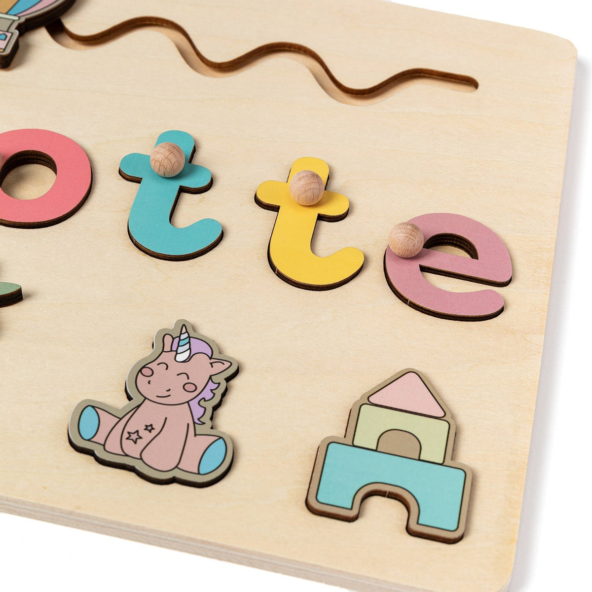 Close-up of the name puzzle letters with unicorn and castle pieces