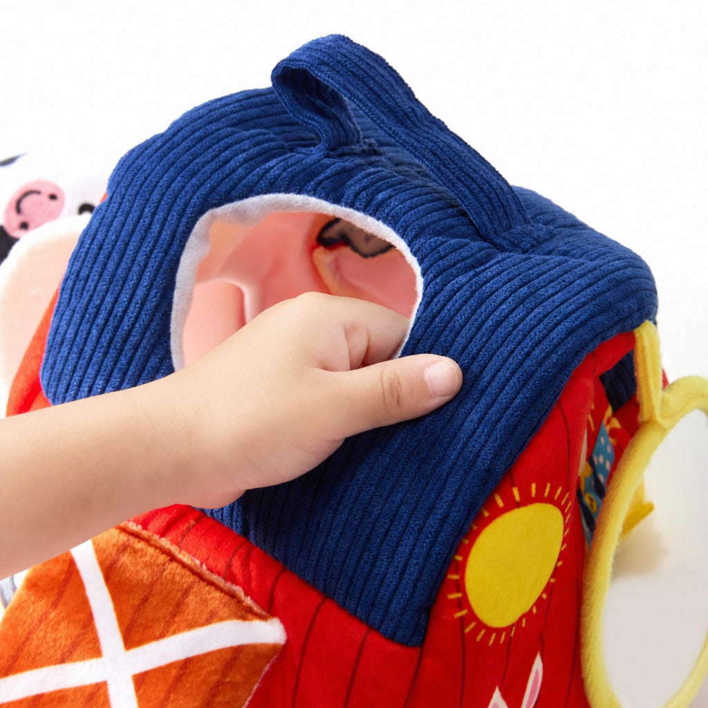 Child's hand lifting a plush animal from the soft barn's loft