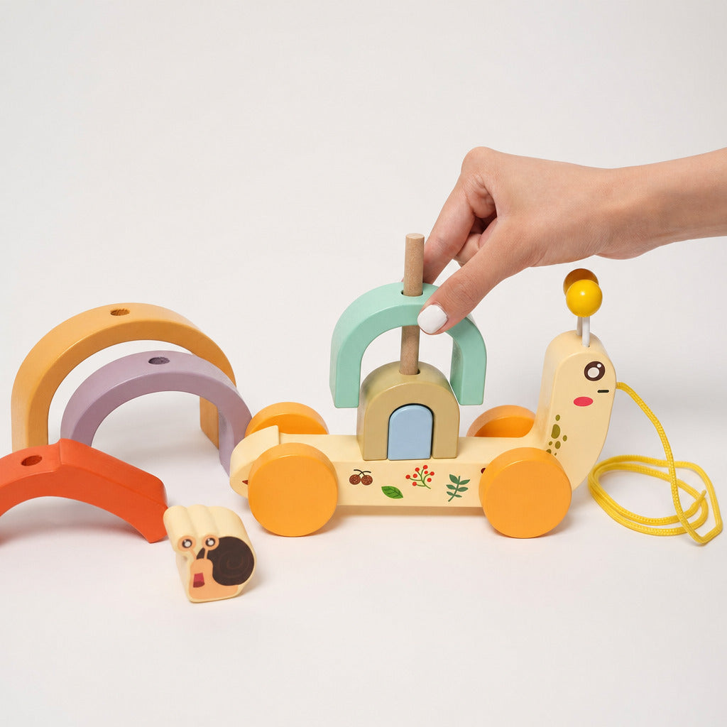 Child stacking the rainbow arcs onto the pull along snail shell