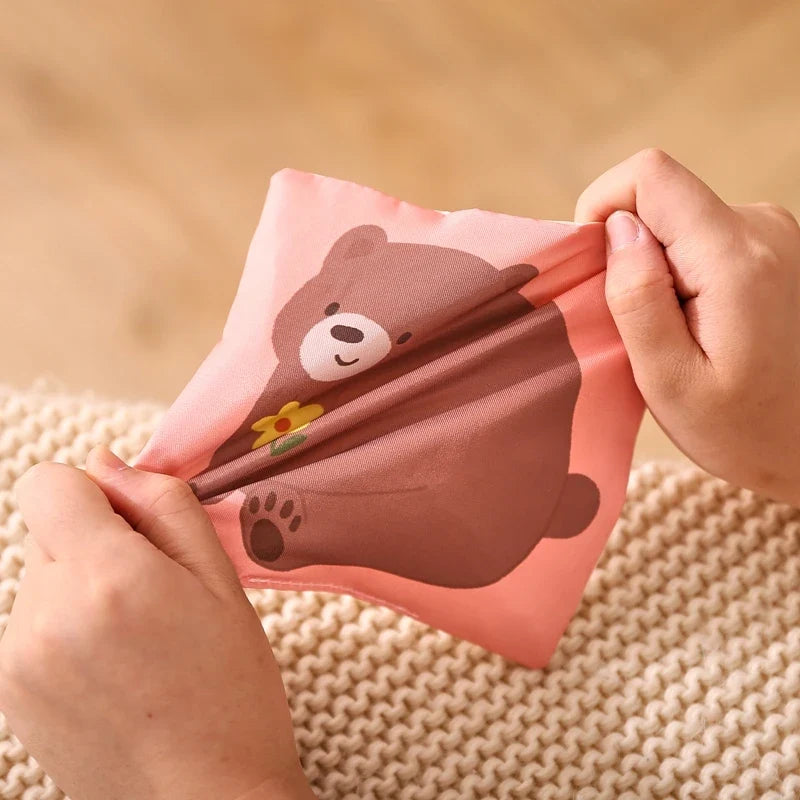 Hands opening the crinkle flap on the bear panel
