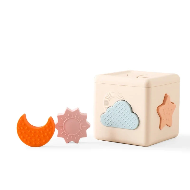 Cream silicone shape sorter cube with moon and sun pieces