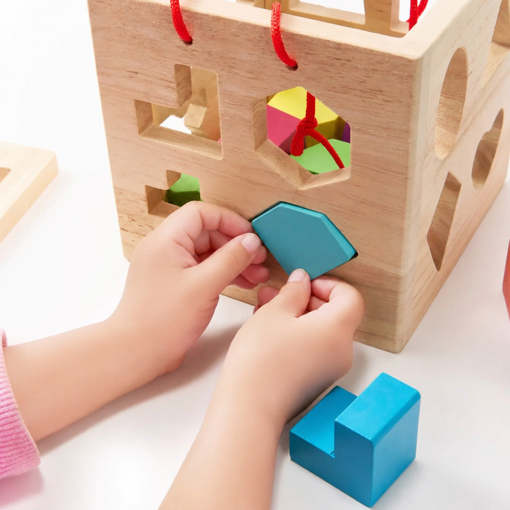 Child posting a blue shape into the wooden shape sorter cube