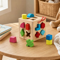 Shape Sorter Cube with Geometric Blocks set out on a real table at home
