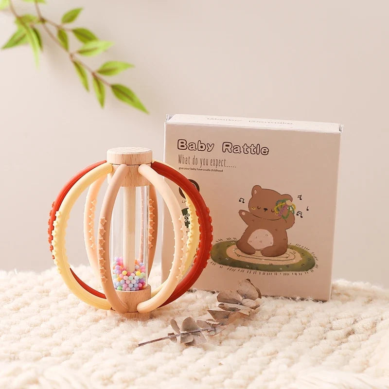 Red and cream teething rattle ball beside its retail box