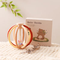Red and cream teething rattle ball beside its retail box