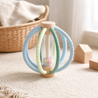 Silicone Teething Rattle Ball – Wooden Sensory Toy set out on a real table at home