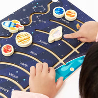 Child placing planet pieces on the constellation puzzle board