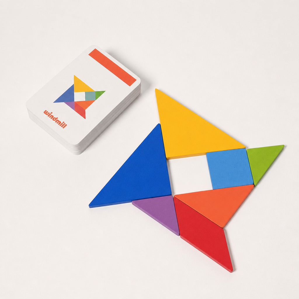 Tangram pieces arranged into a pattern beside the card box