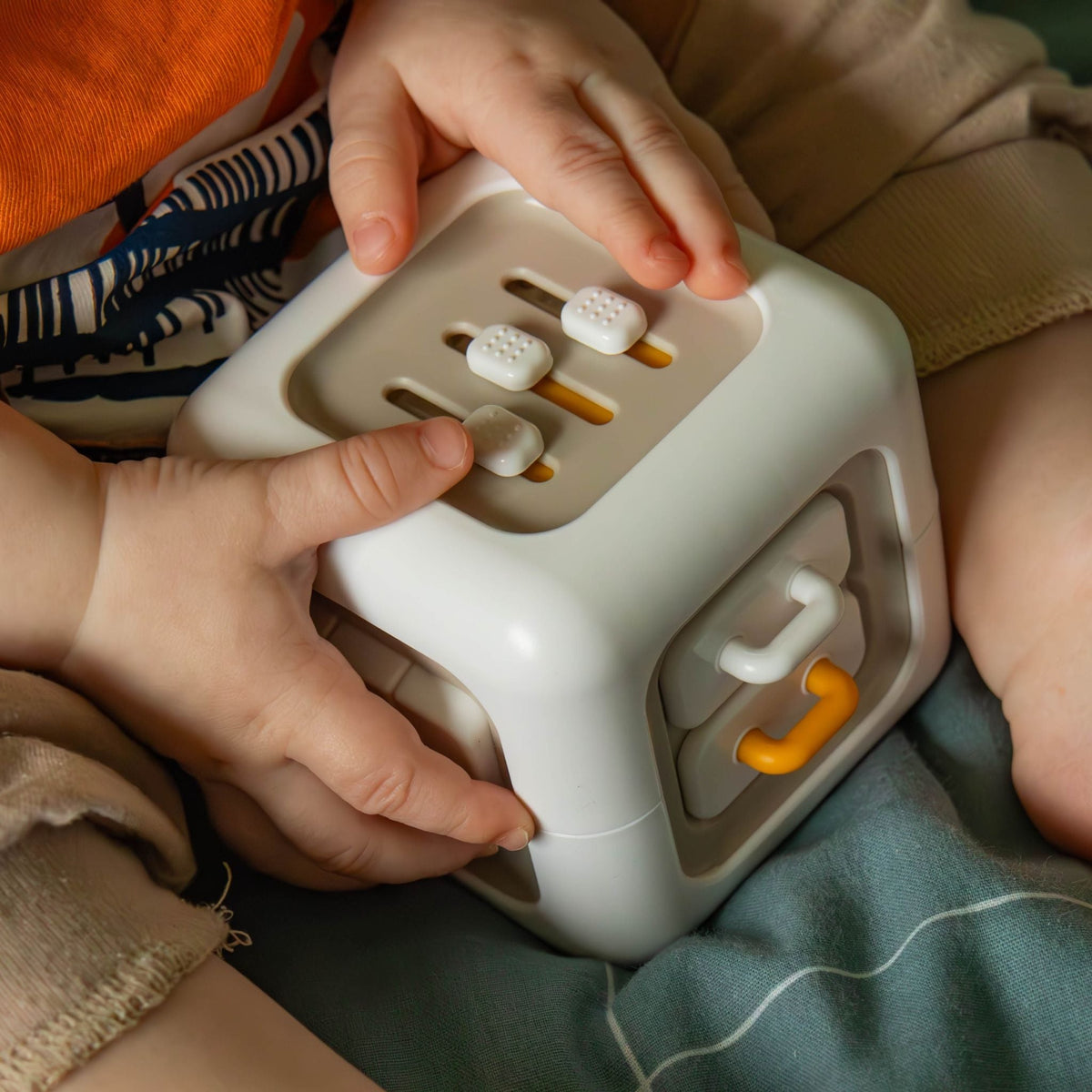 Child pressing the buttons on the silicone sensory busy cube