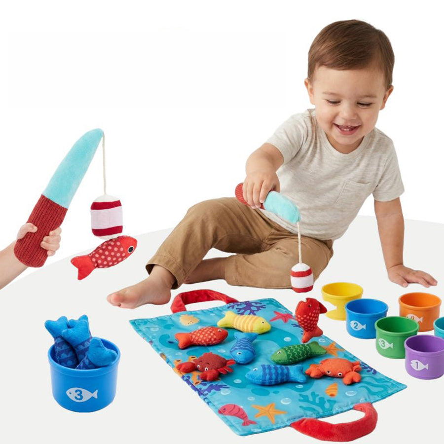 Toddler playing the magnetic fishing and counting game on a mat