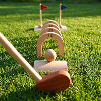 Wooden golf set with numbered arches and club on grass