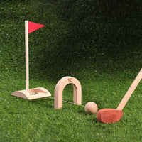 Wooden golf flag, arch and club set up on a lawn