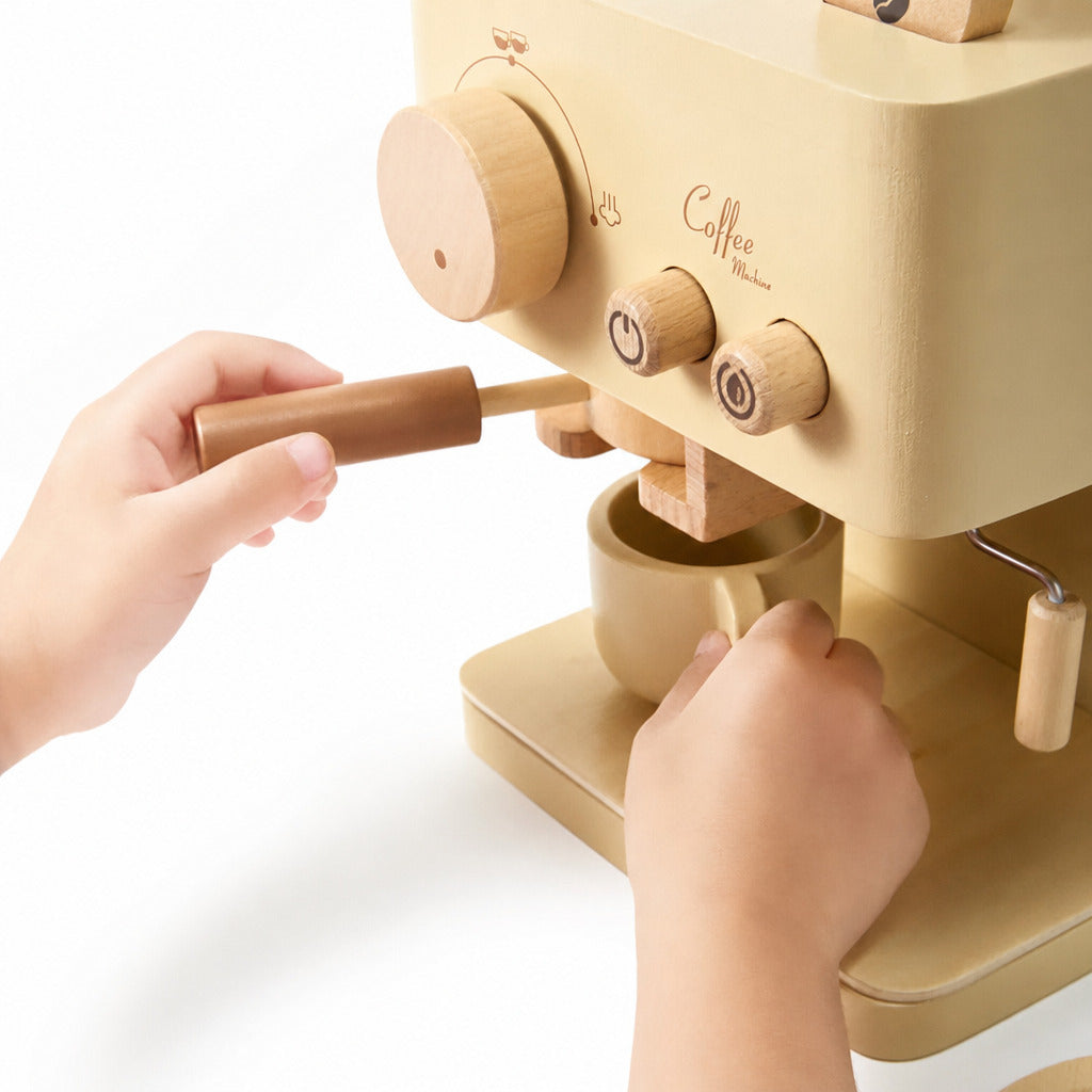 Child's hands working the lever on the wooden toy coffee machine