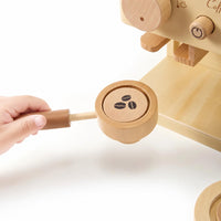 Child's hands turning the wooden coffee grinder dial