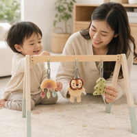 Child using the Wooden Baby Gym with Natural Arch & Hanging Toys