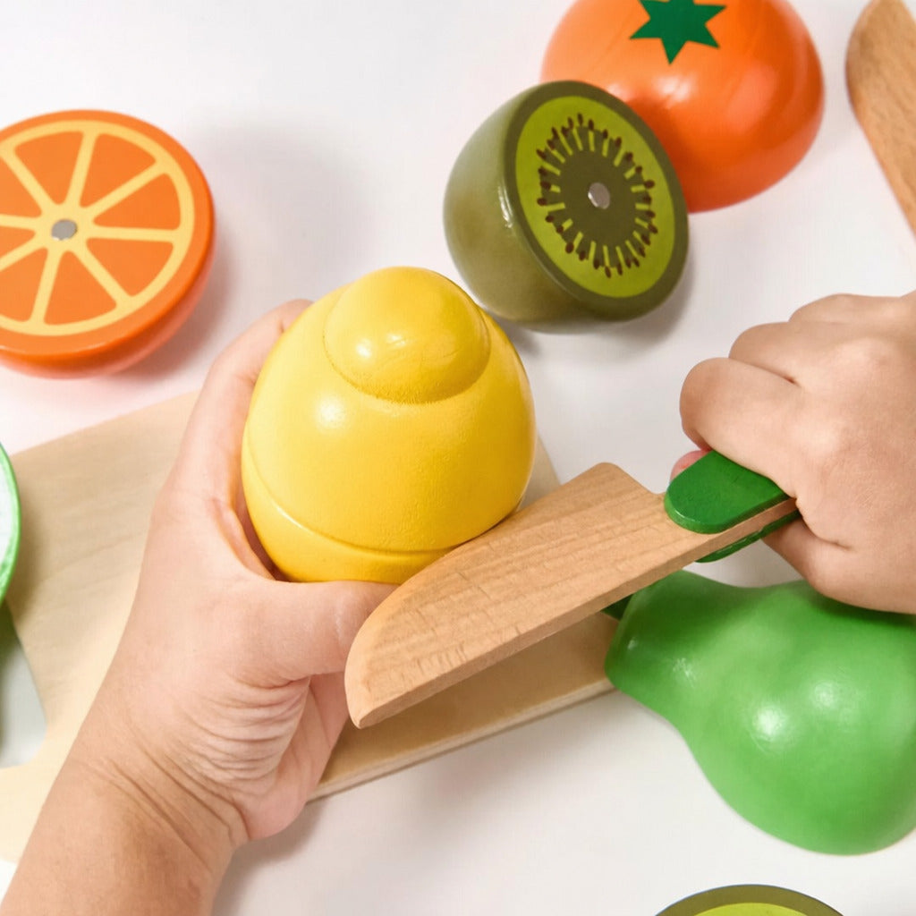 Child slicing a wooden pear with a play knife