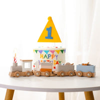 Wooden number train arranged around a first birthday cake
