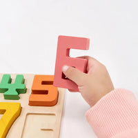 Child fitting the numeral five into the wooden number board