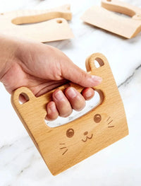 Hand holding the cat-shaped wooden play knife