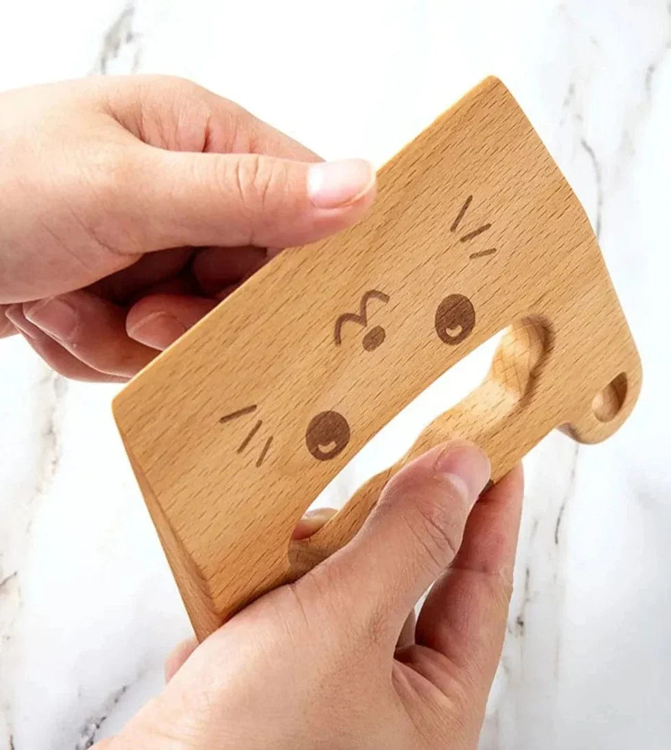 Close-up of the engraved cat face on the wooden play knife